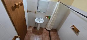 Un baño pequeño con urinario y espejo. en Cabañas Dulce Daniela, en Cerro Negro 98 fotos más