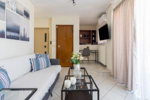 a living room with a white couch and a table at Apartment with a private rooftop in Piraeus
