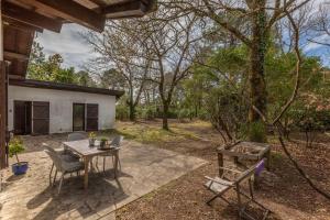 a patio with a table and chairs in a yard at Les clés du bassin in Lège-Cap-Ferret