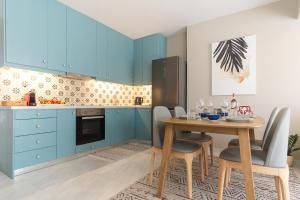 a kitchen with blue cabinets and a table with chairs at Pythagóreio Urban Living in Pythagoreio