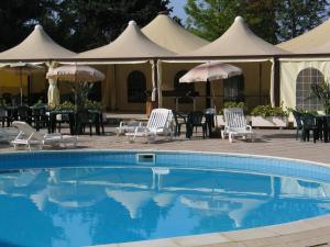 a swimming pool with chairs and umbrellas and tables at Hotel Califfo in Quartu SantʼElena