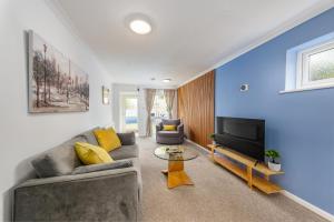 a living room with a couch and a tv at Summer Deal 20 PRC OFF 4BR 2BATH Families Groups By Trinity Stays Short Lets & Serviced Accommodation Cambridge in Cambridge