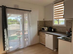 a kitchen with a sink and a window with a balcony at Jesolo Apartmanház in Balatonkeresztúr