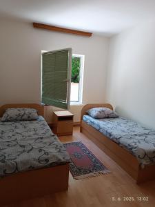 a bedroom with two beds and a window at Apartman ASI in Mostar