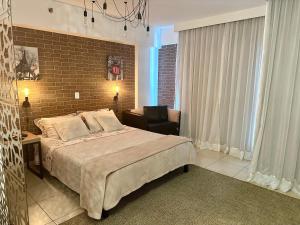 a bedroom with a large bed and a brick wall at Ed Saint Moritz, Flat 02 com Garagem, SHN no Coração de Brasília in Brasilia +37 photos