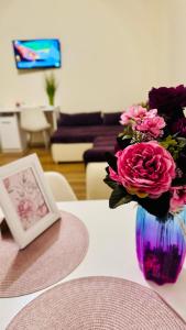 a vase filled with pink flowers sitting on a table at SHoliday La Parter cu Parcare Privată și Spațiu Modern in Dumbrăviţa