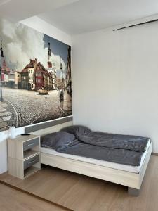 a bedroom with a bed with a painting on the wall at Jesolo Apartmanház in Balatonkeresztúr