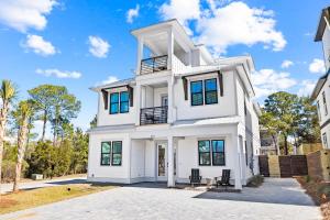una casa blanca con ventanas azules en The Bungalow by Travel Life Vacations, en Destin