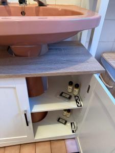 a bathroom with a pink sink on a shelf at Casa das Muralhas in Peniche +11 photos