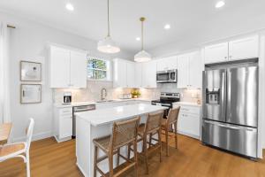 a kitchen with white cabinets and a large kitchen island at The Bungalow by Travel Life Vacations in Destin