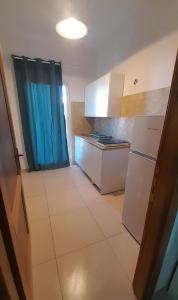 a small kitchen with a refrigerator and a stove at Bilocale Su Lizzu de Erminia in La Caletta +3 photos