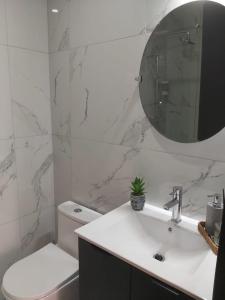 a white bathroom with a sink and a mirror at Espectacular apartamento en Obarrio in Panama City +5 photos