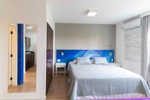 une chambre avec un grand lit avec une tête de lit bleue dans l'établissement Prime Flat - Metrópolis Alphaville, à Barueri 35 autres photos