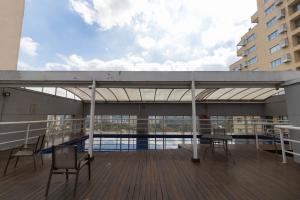 a balcony with tables and chairs on a building at Prime Flat - Metrópolis Alphaville in Barueri