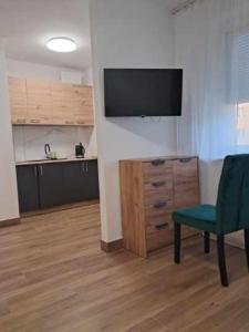 ビャウィストクにあるAPARTAMENT CENTRUM Sobieskiegoのリビングルーム(テレビ、緑の椅子付)