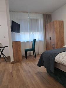 ビャウィストクにあるAPARTAMENT CENTRUM Sobieskiegoのベッドと椅子とテレビのある寝室