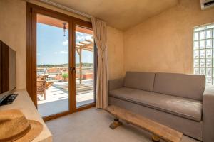 a living room with a couch and a large window at Delmare Tower View Suites in Nea Fokea