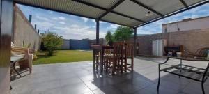 a patio with a table and chairs under a roof at M&P alquiler por día in La Rioja