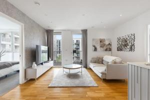 a living room with a couch and a table at Luxury 2 Bed Apt in Olympic Village in London
