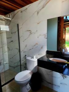 a bathroom with a toilet and a sink and a mirror at Pousada Casa do Campo Zelito in Delfinópolis +37 photos