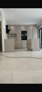 a large room with a kitchen with white cabinets at Thechillhome in Tigery