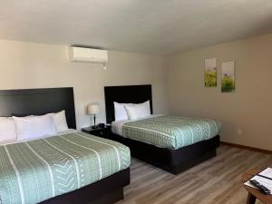 a hotel room with two beds and a table at DownTown Inn in Sister Bay