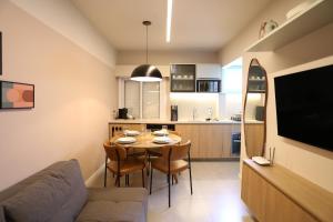 a living room and kitchen with a table and chairs at Flat SP Suítes - Apartamentos por temporada in Sao Paulo +37 photos