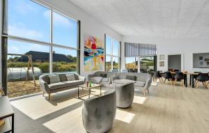 a living room with couches and tables and windows at Gorgeous Home In Ringkøbing With Sauna in Ringkøbing