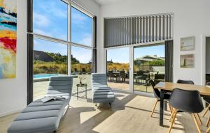 a living room with a table and chairs and windows at Gorgeous Home In Ringkøbing With Sauna in Ringkøbing