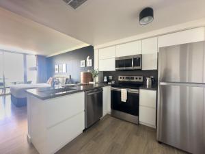 a kitchen with white cabinets and a stainless steel refrigerator at MVR-Sunset Luxury You Can-t Find Anywhere Else in Miami