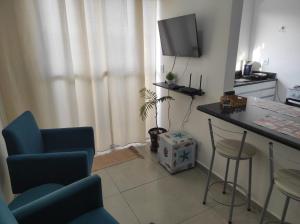 a living room with a table and chairs and a television at Apt no Santa Mônica próximo ao Pátio Sabiá, UFU in Uberlândia