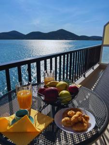 a table with a plate of food and a glass of orange juice at Costalia Seafront Apt in Elounda +14 photos