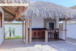 ein Haus mit einem Tisch und einem Strohdach in der Unterkunft Vila Carnaúba no condomínio Praia Canoé Fortim in Barra (2)