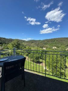 einen Balkon mit einem Tisch und Bergblick in der Unterkunft La Vallée Appartement 34 - Thermes Neyras les Bains in Meyras