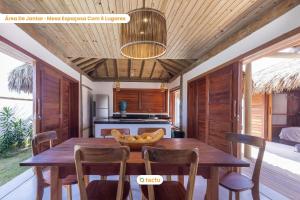 ein Esszimmer mit einem Holztisch und Stühlen in der Unterkunft Vila Carnaúba no condomínio Praia Canoé Fortim in Barra (2)