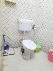 a bathroom with a toilet in a tiled wall at Gokul PG Homestay in Gorakhpur +20 photos