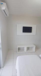 une pièce blanche avec une télévision au mur dans l'établissement Hotel Executivo formosa, à Formosa