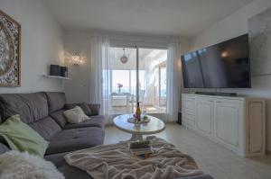a living room with a couch and a flat screen tv at Vista Divina in Cumbre del Sol