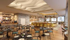 a restaurant with tables and chairs and a bar at voco Ma Belle Danang by IHG in Da Nang