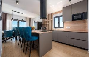 eine Küche mit einer Insel mit blauen Barhockern in der Unterkunft Amazing Home In Maslenica With Sauna in Maslenica