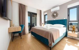 ein Schlafzimmer mit einem großen Bett mit blauem Kopfteil in der Unterkunft Amazing Home In Maslenica With Sauna in Maslenica