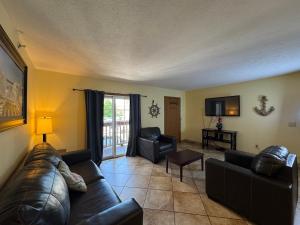 a living room with a leather couch and two chairs at Put-in-Bay Poolview Condo #5 in Put-in-Bay