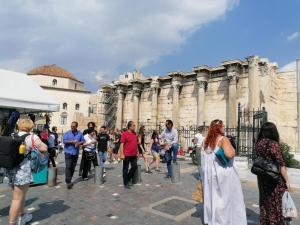eine Gruppe von Menschen, die vor einem Gebäude spazieren gehen in der Unterkunft Acropolis views in Monastiraki square in Athen + 8 Fotos