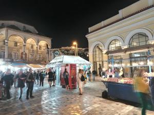 eine Gruppe von Menschen, die nachts auf einem Markt spazieren in der Unterkunft Acropolis views in Monastiraki square in Athen