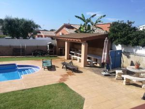 a backyard with a pool and a table and an umbrella at casa con piscina Comarruga in Comarruga