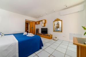 a bedroom with a blue bed and a tv at Casa di Zia Rosaria SEA VIEW in Vietri sul Mare +42 photos