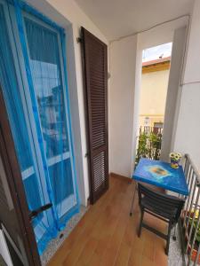 a room with a blue table and a balcony at Affittacamere Girasole in Foligno
