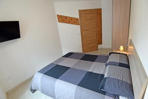 a bedroom with a bed and a tv on a wall at Casa Angelini in Castello di Fiemme
