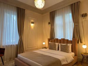 a bedroom with a large bed in front of windows at House4You - Praporgescu in Bucharest +98 photos