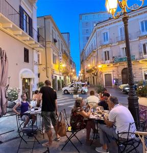 a group of people sitting at tables on a city street at Historic Old Townhouse in center of Chieti in Chieti +46 photos